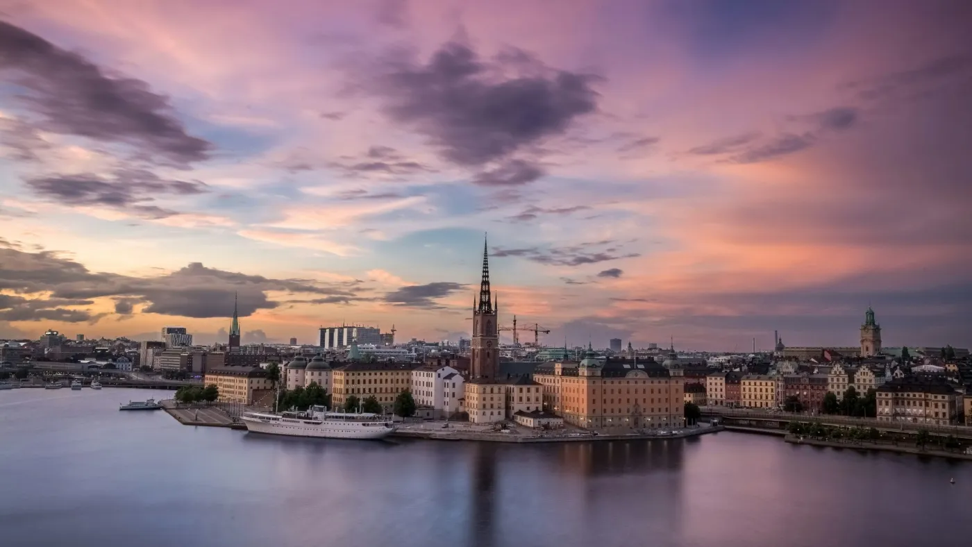 A spectacular view of Stockholm from the water with tones of red on the sky